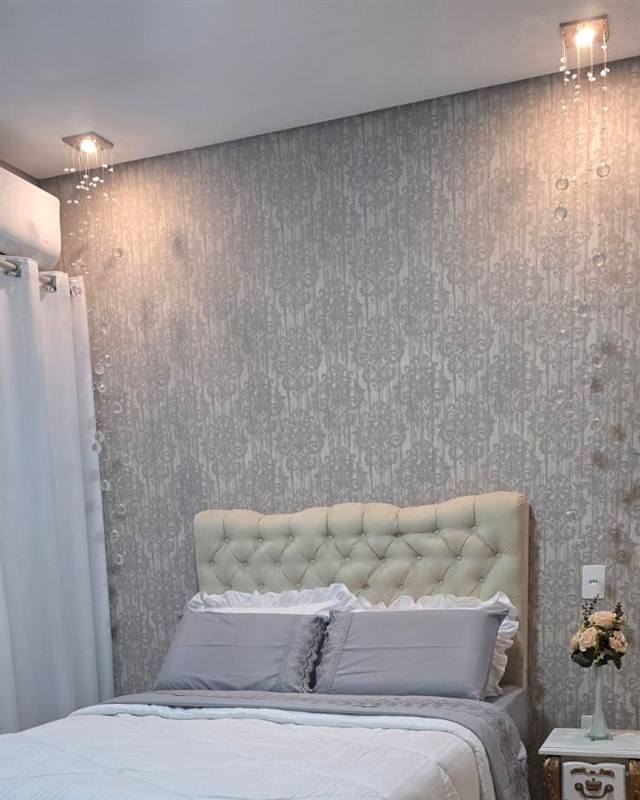 Cortina branca de ilhós ao lado da cama em quarto decorado